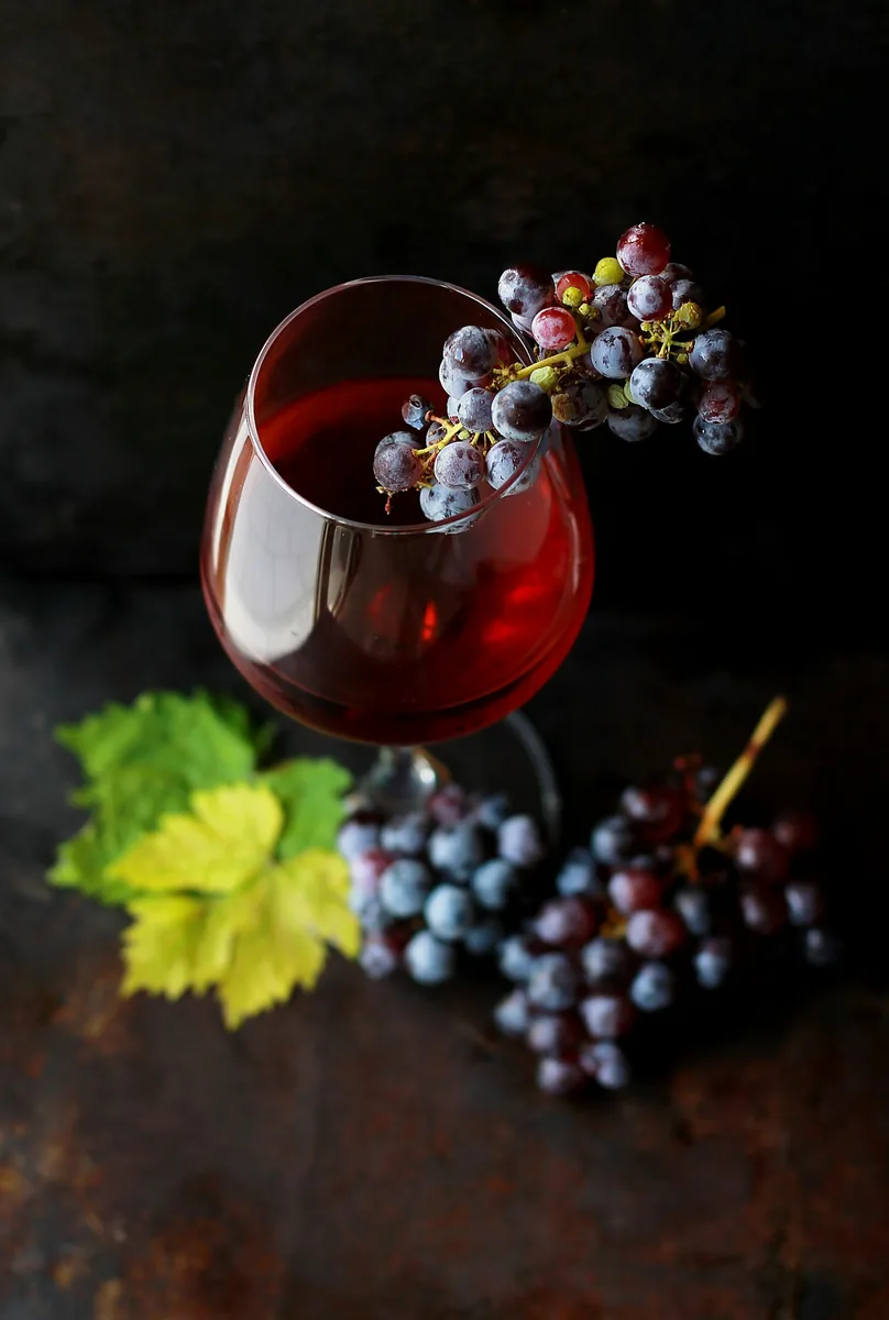 Racimo de uvas oscuras sobre la mesa, consumo de alcohol con moderación