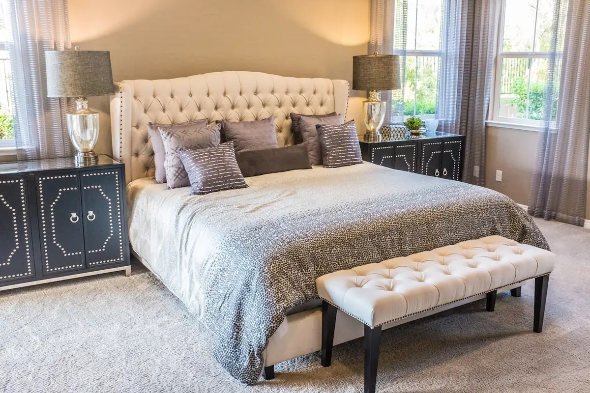 Dormitorio ordenado con cama tendida junto a una ventana, ambiente para descansar bien